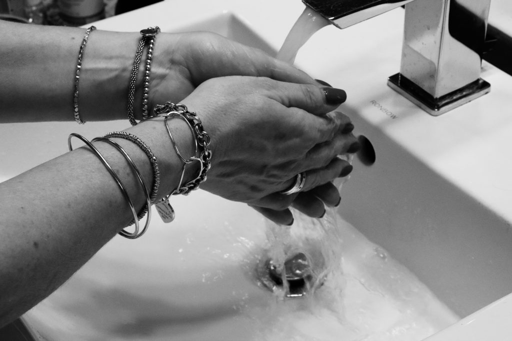 Women's hands as she washes them in the bathroom. 
