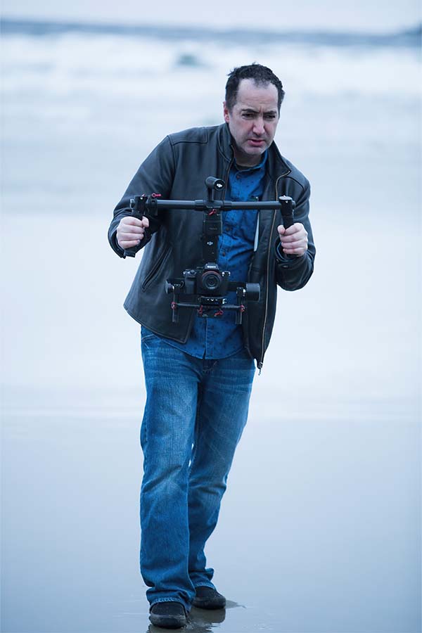 Jarrod Tully standing and holding a gimbal. 