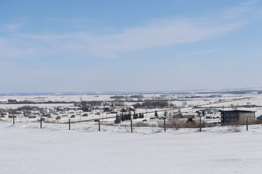 Buildings and flat land covered in a layer of snow on a cold winter day.