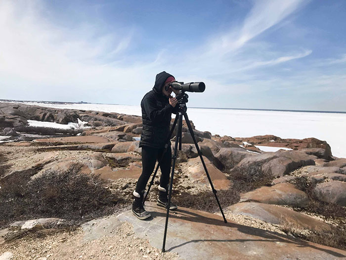 Mitchell looking through a scope in Churchill. / MADDY MITCHELL